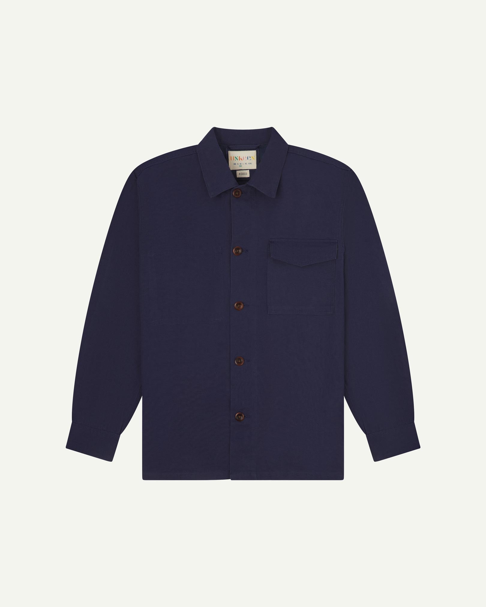 Midnight blue buttoned organic cotton workshirt from Uskees with clear view of chest pocket and Uskees branding label.