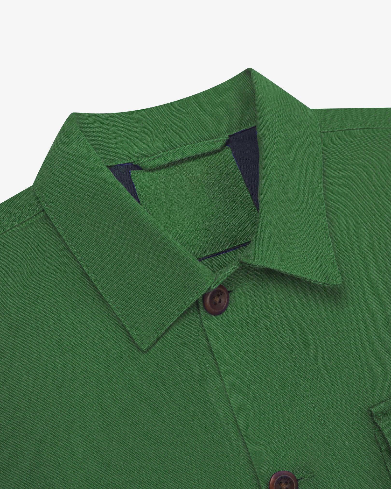 Close-up top-half view of #3003, mint green organic cotton workshirt. With focus on collar, Uskees brand label and corozo buttons.