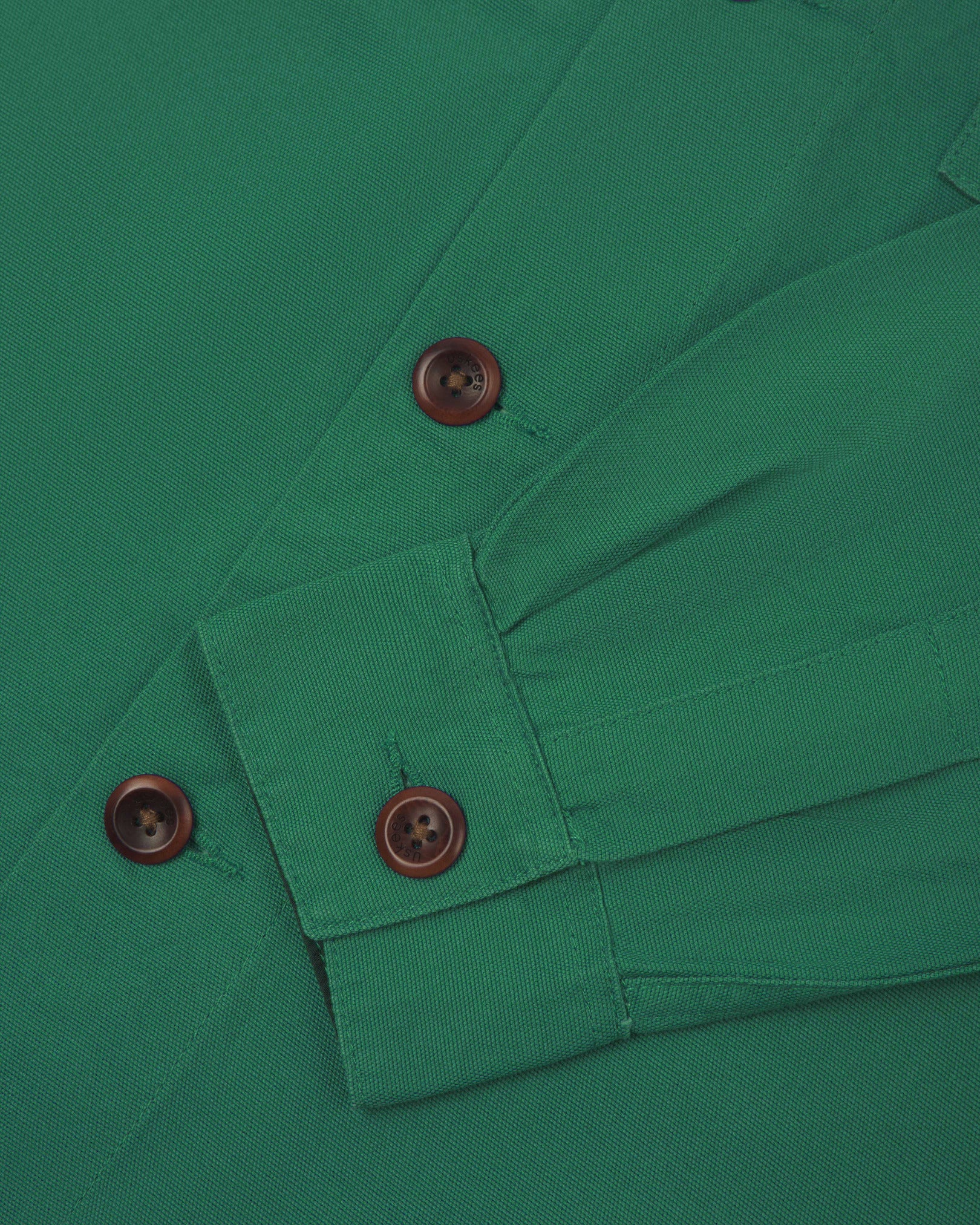 View of the mid-section and sleeve of the 3003 Uskees button-down work shirt in mint green with focus on cuff, placket and corozo buttons.