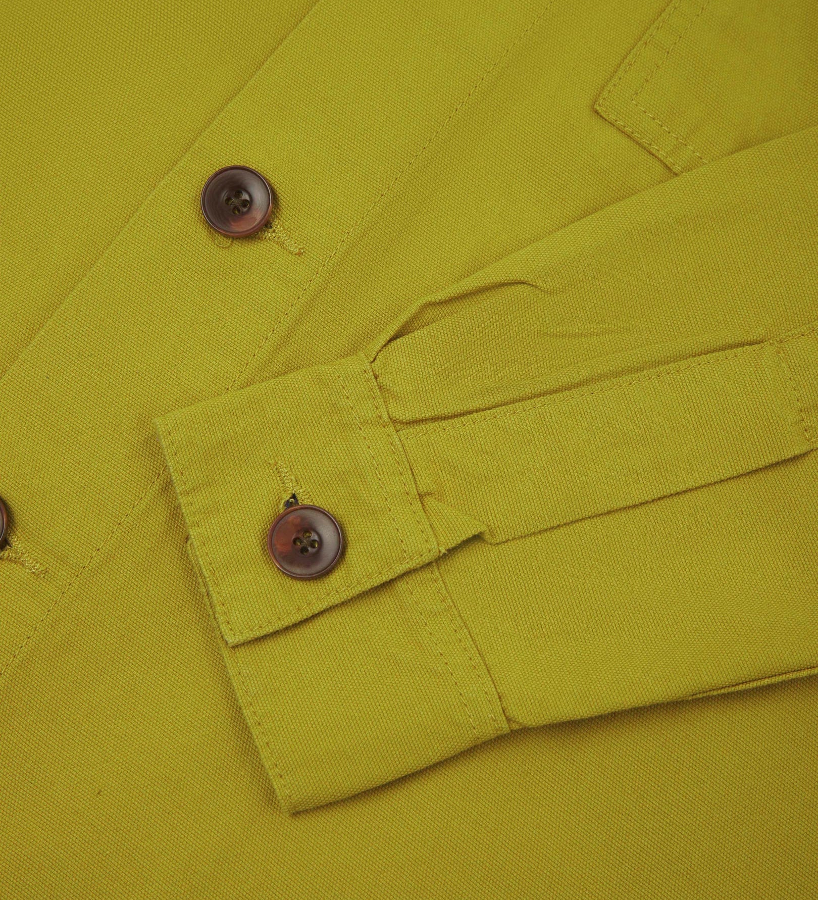 View of the mid-section and sleeve of the 3003 Uskees button-down work shirt in 'pear' with focus on cuff, placket and corozo buttons.