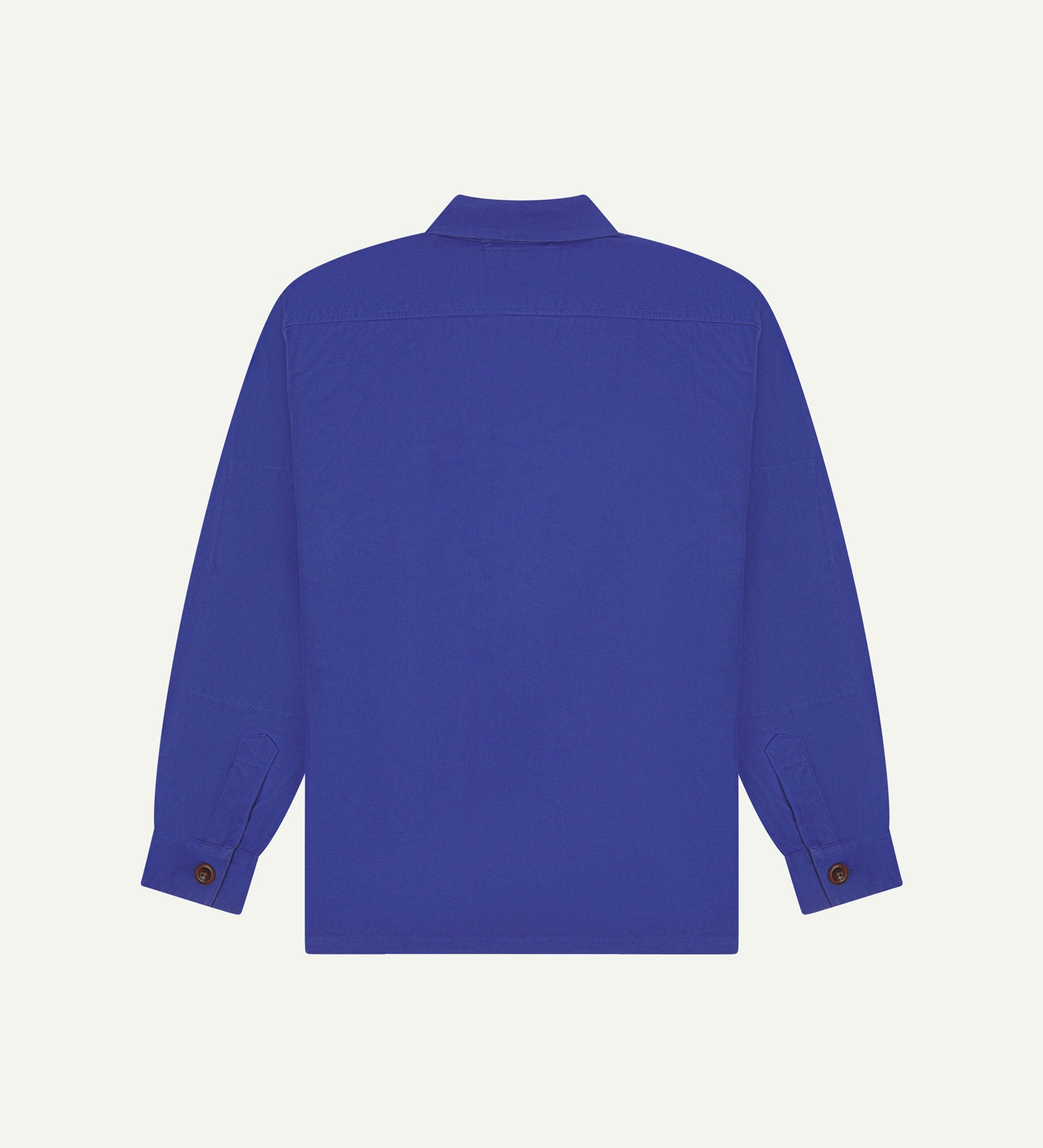 Reverse of ultra blue buttoned organic cotton workshirt from Uskees showing reinforced elbows, tailored cuffs and boxy silhouette.