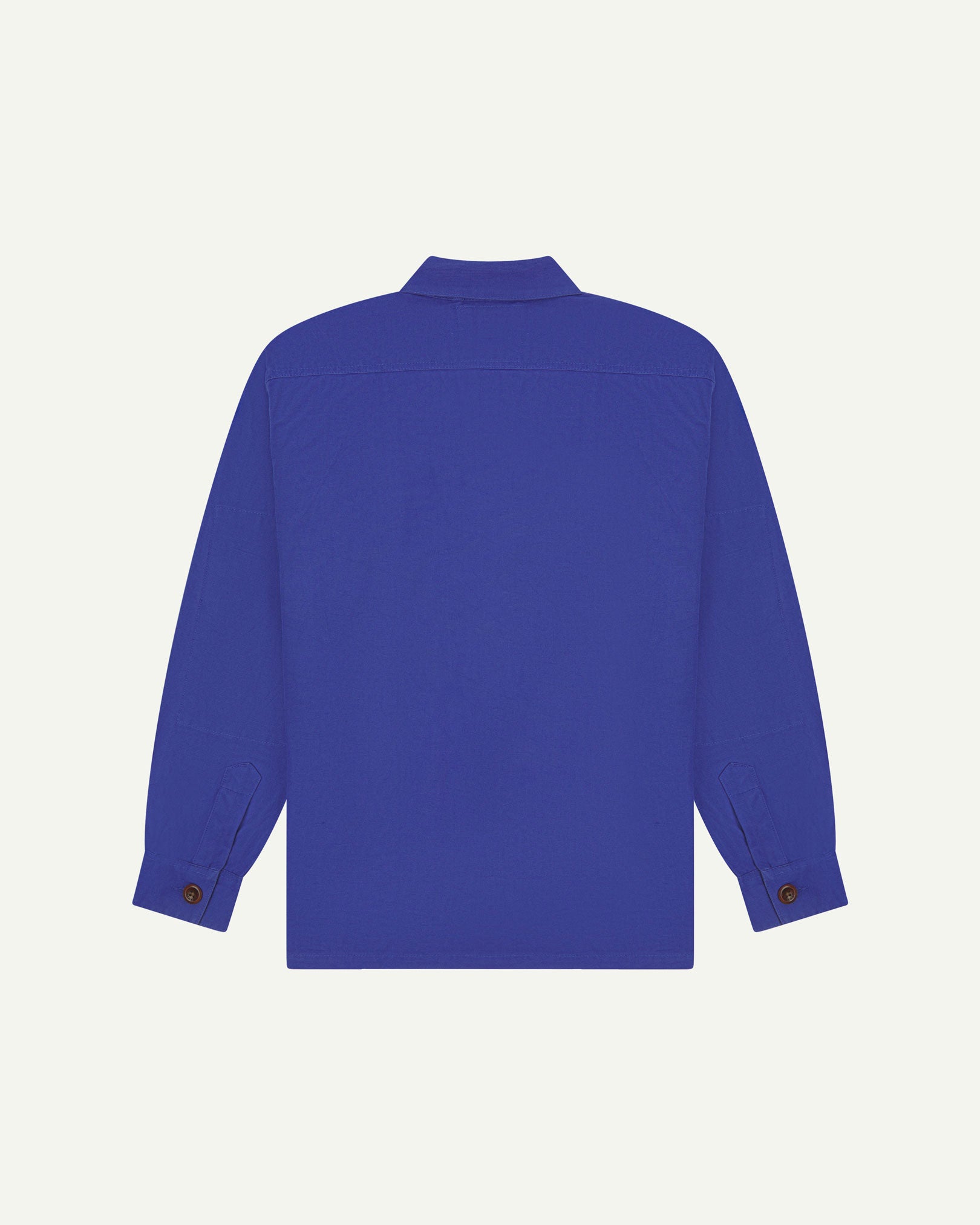 Reverse of ultra blue buttoned organic cotton workshirt from Uskees showing reinforced elbows, tailored cuffs and boxy silhouette.