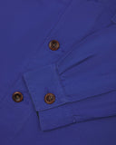 View of the mid-section and sleeve of the 3003 Uskees button-down work shirt in ultra blue with focus on cuff, placket and corozo buttons.