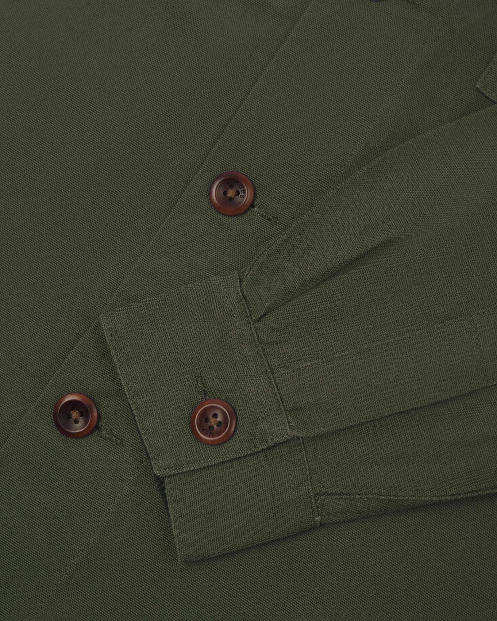 View of the mid-section and sleeve of the 3003 Uskees button-down work shirt in vine green with focus on cuff, placket and corozo buttons.