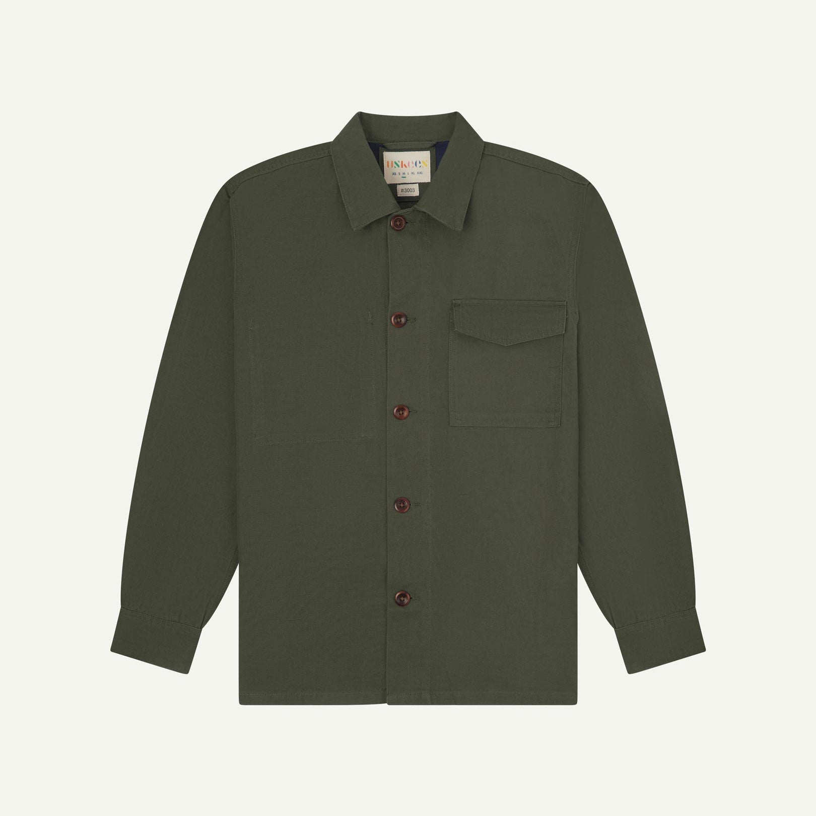 Vine green buttoned organic cotton workshirt from Uskees with clear view of chest pocket and Uskees branding label.