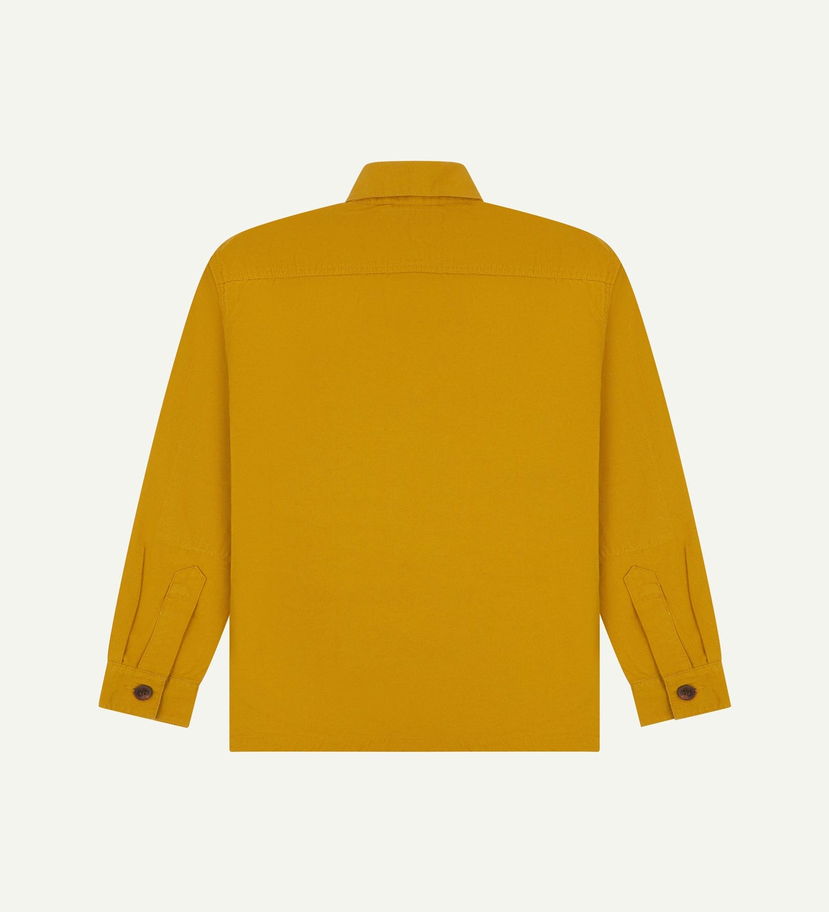 Reverse of yellow buttoned organic cotton workshirt from Uskees showing reinforced elbows, tailored cuffs and boxy silhouette.