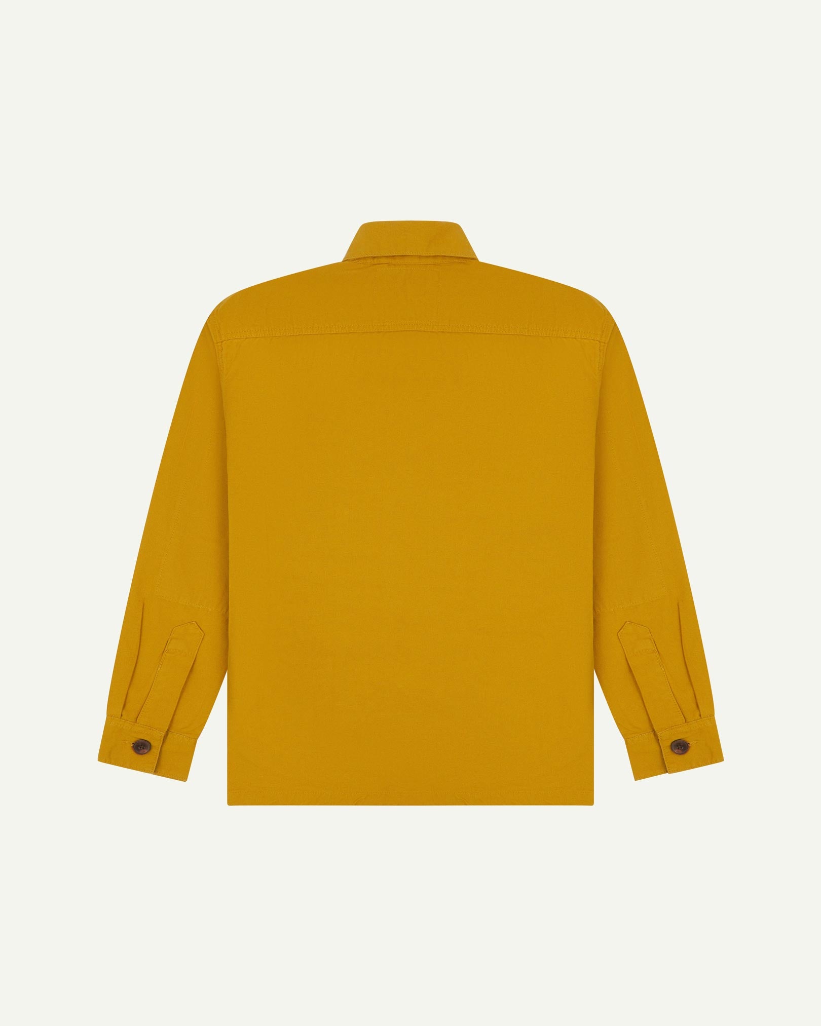 Reverse of yellow buttoned organic cotton workshirt from Uskees showing reinforced elbows, tailored cuffs and boxy silhouette.
