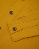 View of the mid-section and sleeve of the 3003 Uskees button-down work shirt in yellow with focus on cuff, placket and corozo buttons.