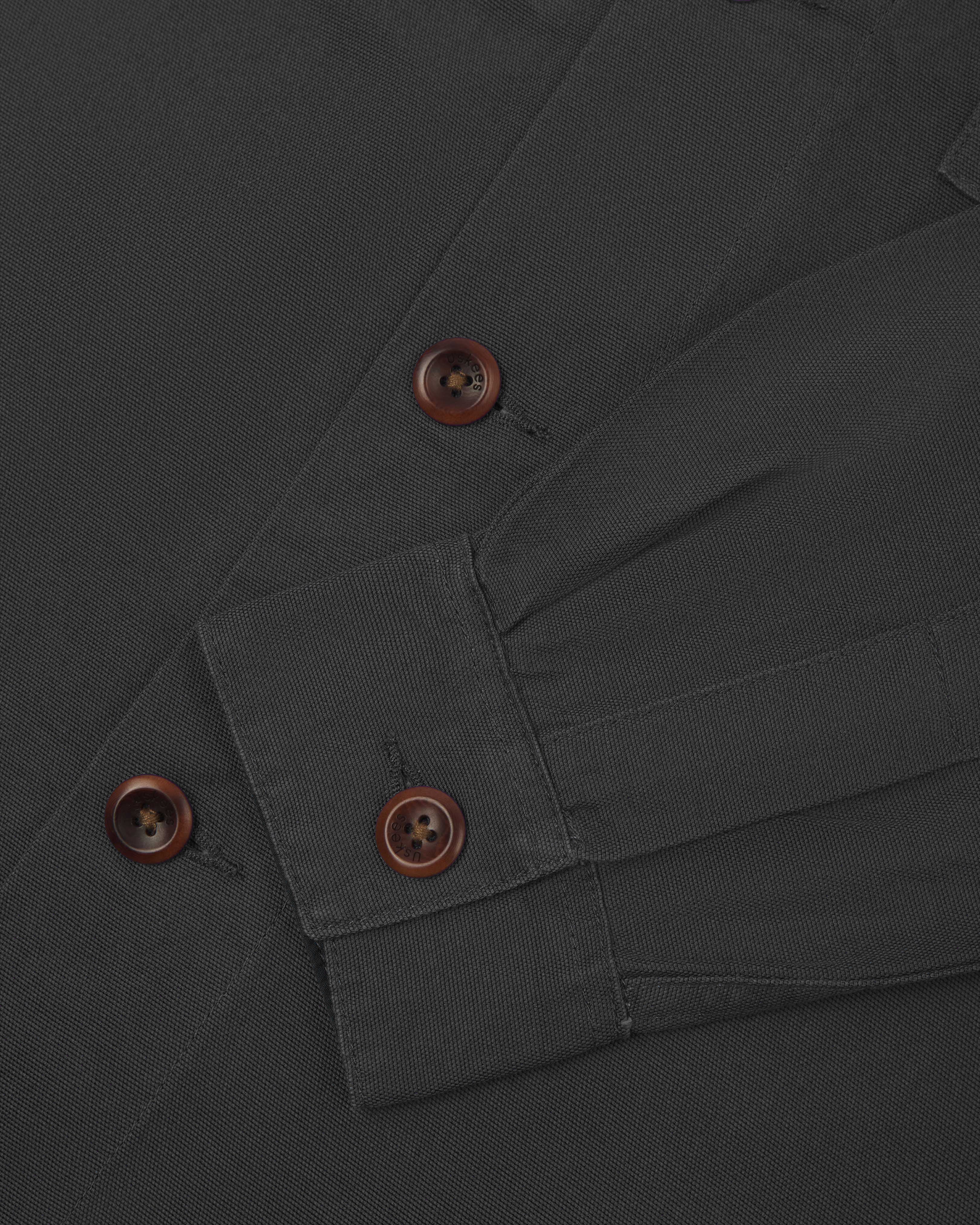 Front close view of dark grey buttoned 3003 workshirt for men from Uskees. Showing brown corozo buttons and sleeve/cuff detail.