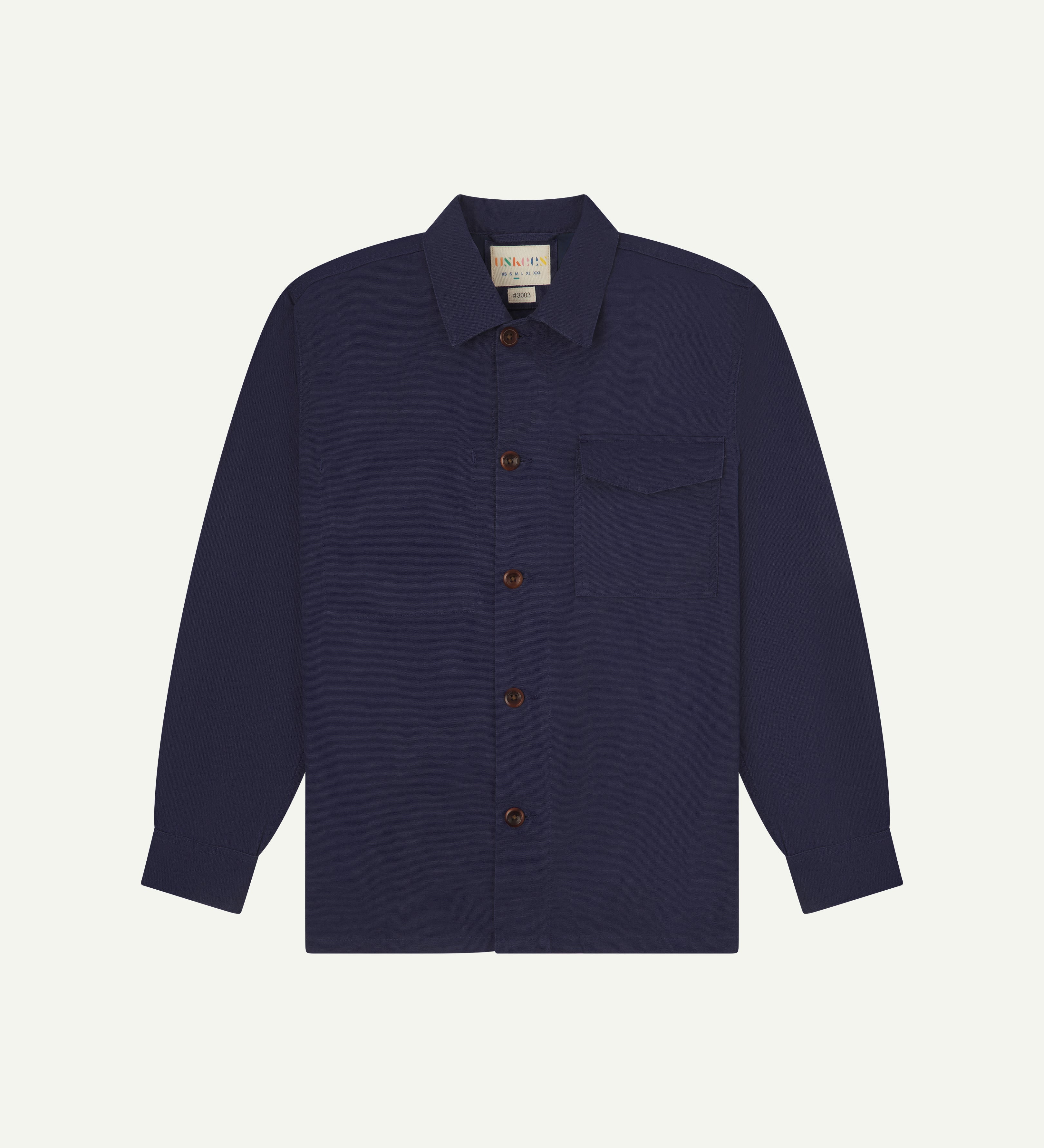 Front flat shot of dark blue #3003 workshirt from Uskees. Showing chest pocket with flap and corozo buttons.