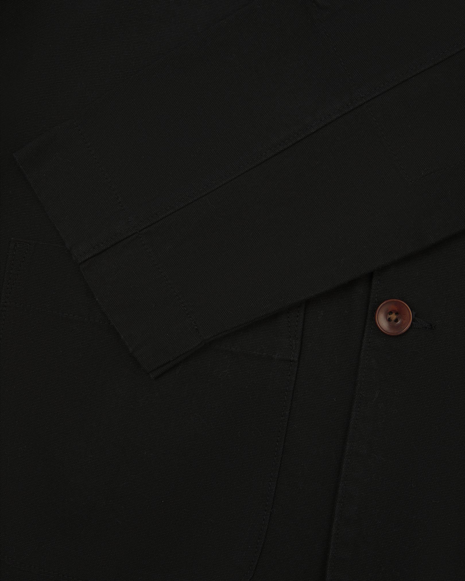 Close-up view of cuff and placket of organic cotton, black blazer from Uskees.