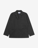 Full front view of black buttoned organic cotton-twill blazer from Uskees with clear view of three patch pockets and Uskees branding label.