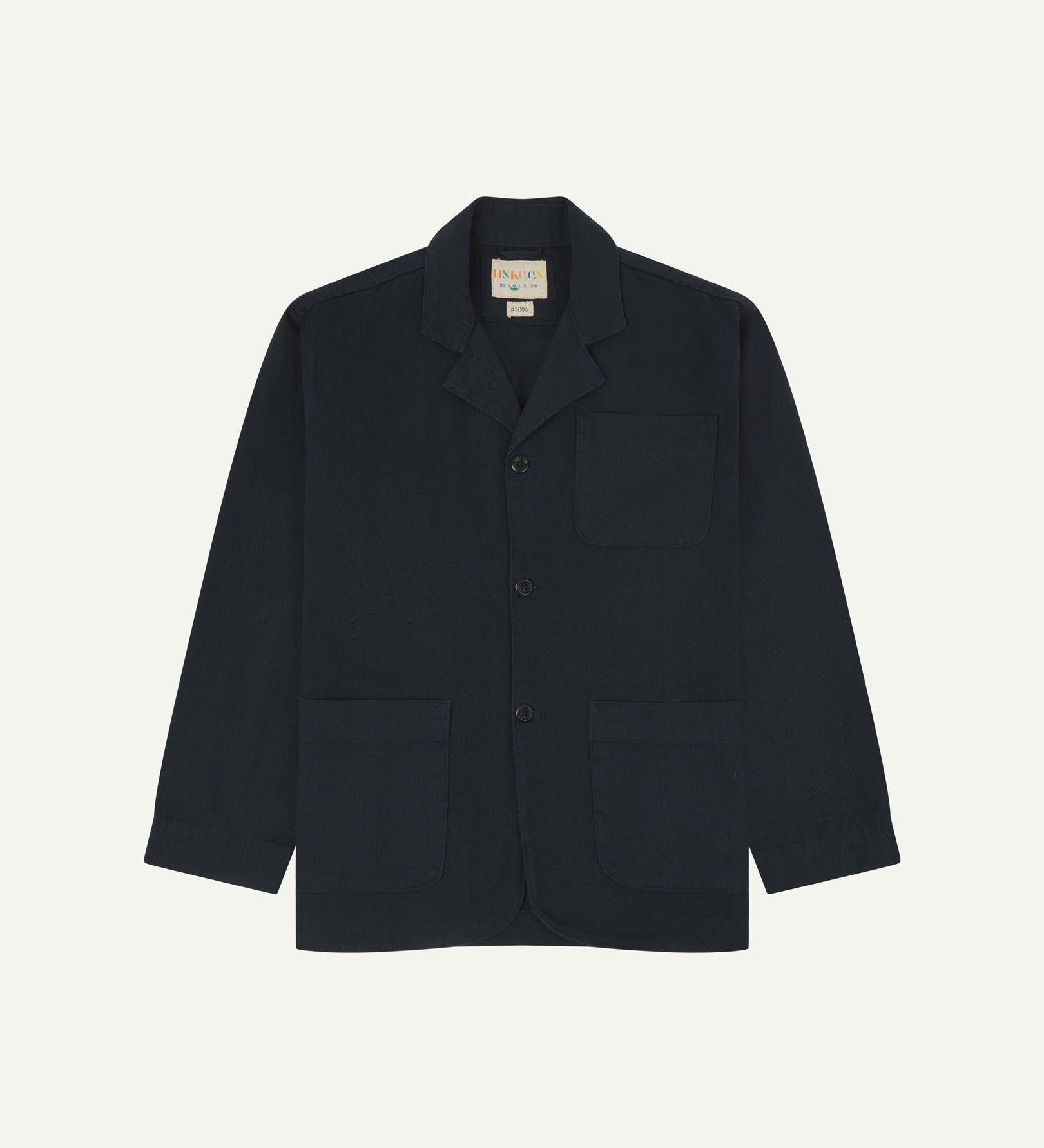 Dark blue (blueberry) buttoned organic cotton-drill blazer from Uskees with clear view of three patch pockets and Uskees branding label.