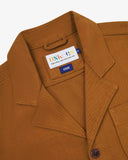 Angled top-half view of #3006, buckthorn (mustard yellow) organic cotton-drill blazer. With focus on collar, notch lapels, breast pocket, Uskees brand label and corozo buttons.