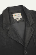 Close-up front view of organic cord charcoal-grey blazer showing the collar, lapels and Uskees brand label.
