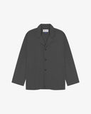 Charcoal-grey buttoned organic cotton-drill blazer from Uskees with clear view of three patch pockets and Uskees branding label.