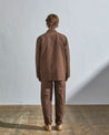 Full length back view of model wearing chocolate-brown cotton #3006 Uskees blazer. Paired with matching pants.