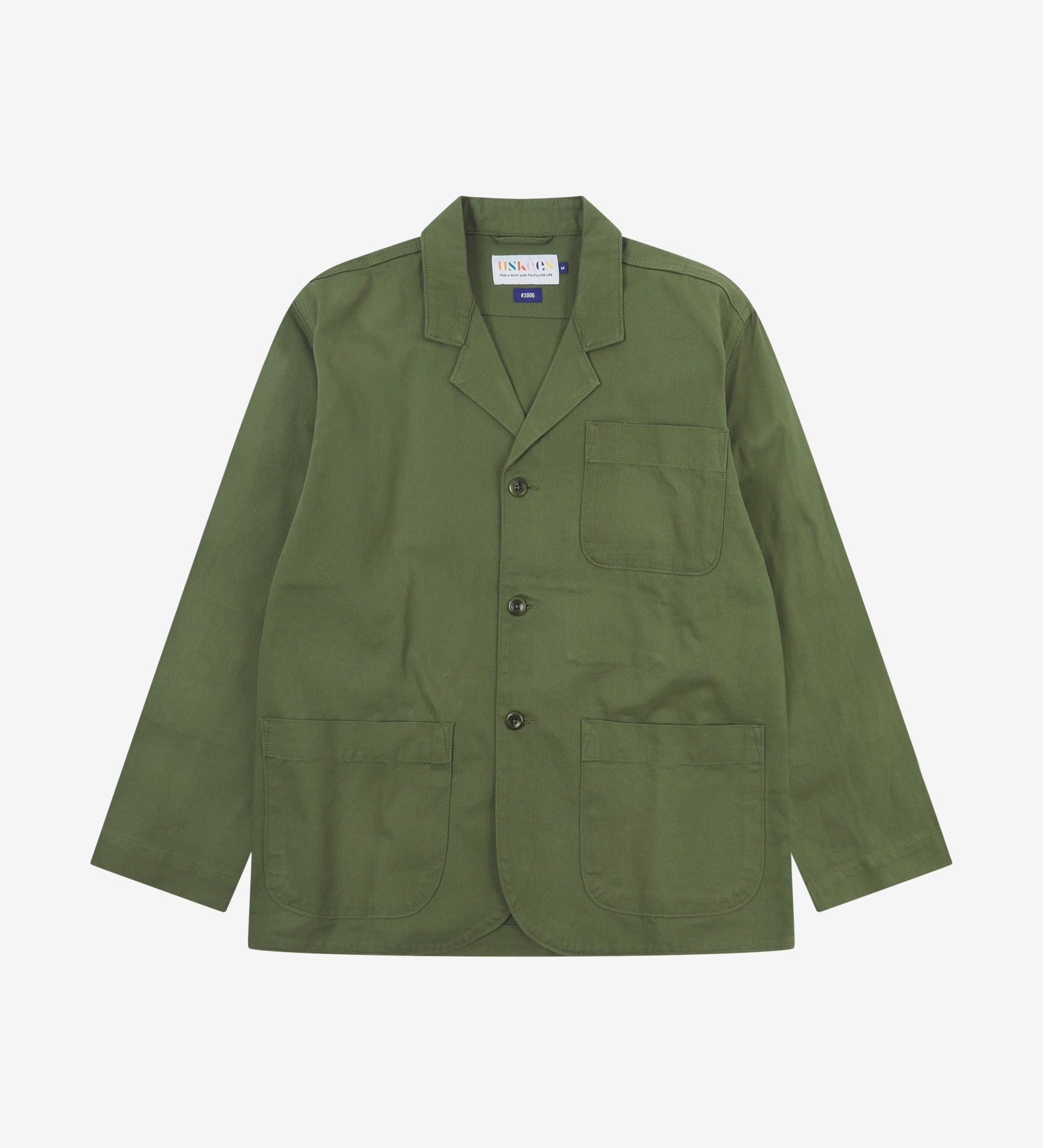 Full front view of coriander-green buttoned organic cotton-twill blazer with clear view of three patch pockets and Uskees branding label.