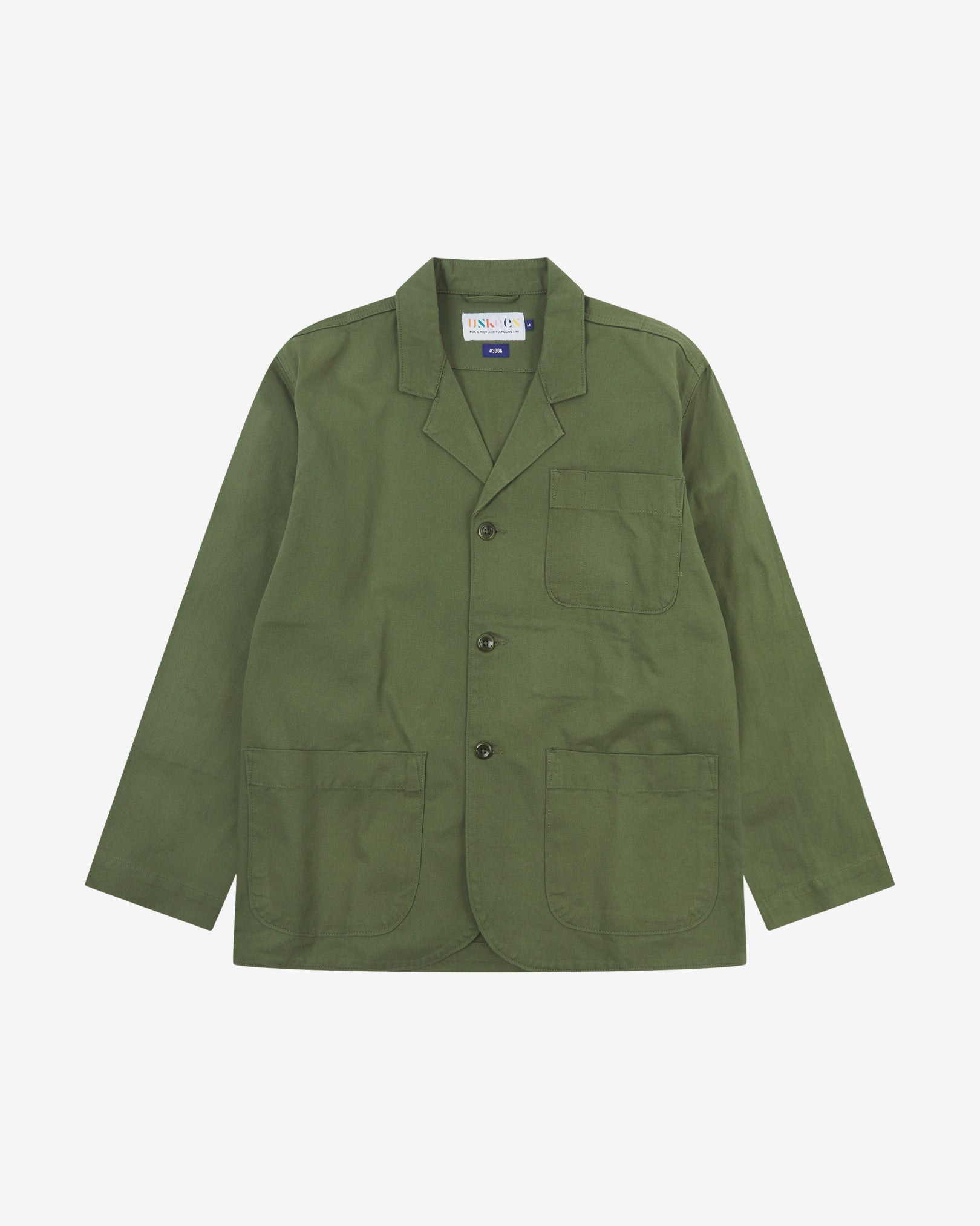 Full front view of coriander-green buttoned organic cotton-twill blazer with clear view of three patch pockets and Uskees branding label.