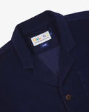 Close-up front view of organic cord deep indigo blazer showing the collar, lapels and Uskees brand label.