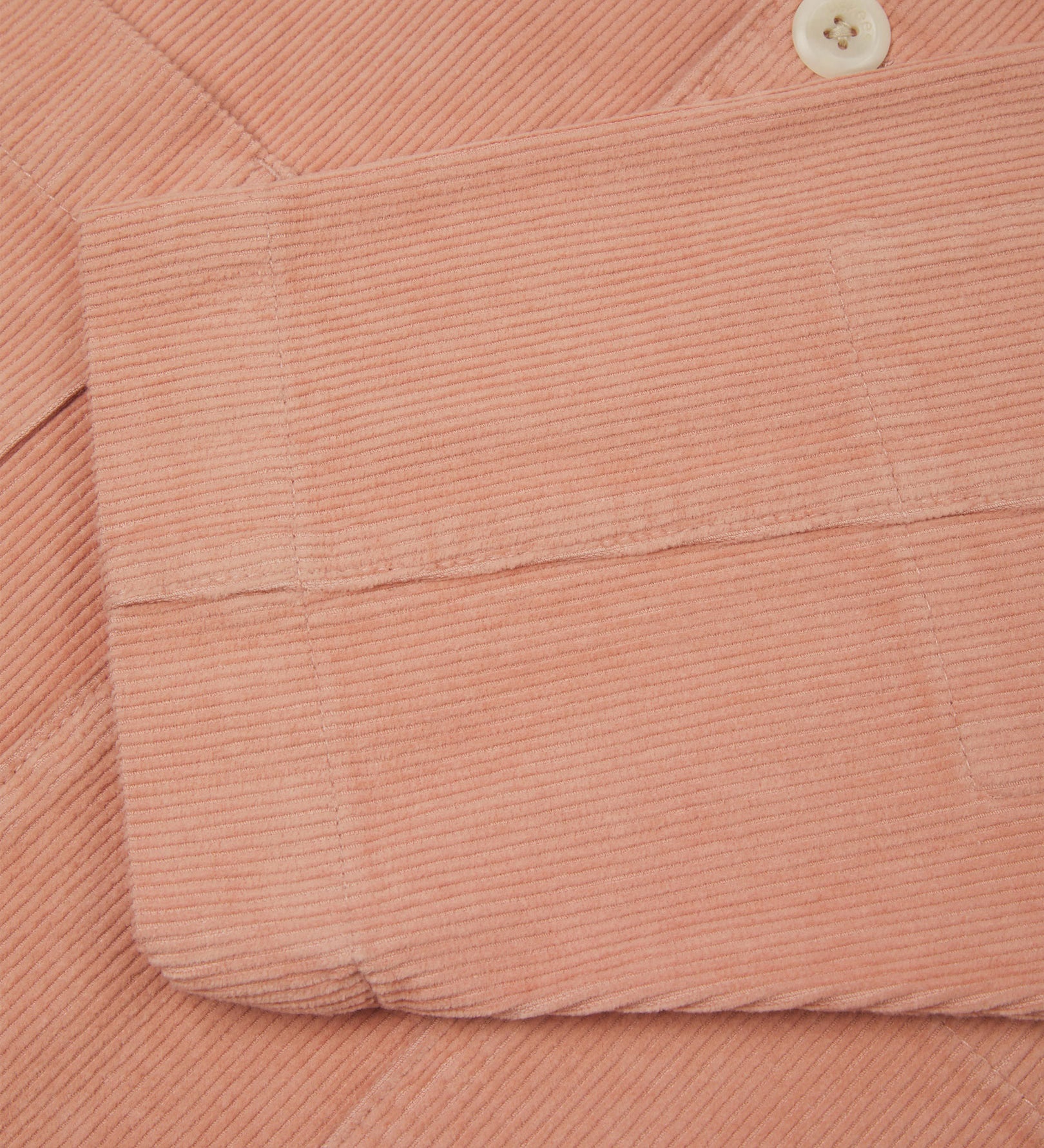 Close-up view of cuff, placket and corozo buttons of organic corduroy, 'dusty pink' blazer from Uskees.