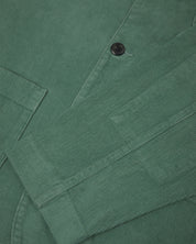 Close-up view of cuff, placket and corozo buttons of organic corduroy, eucalyptus-green blazer from Uskees.
