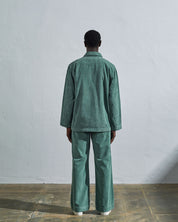 Full length back view of model wearing eucalyptus-green corduroy #3006 Uskees blazer, with view of reinforced elbows and boxy fit.