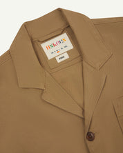 Close-up front view of organic cotton khaki green blazer showing the collar, lapels and Uskees brand label.