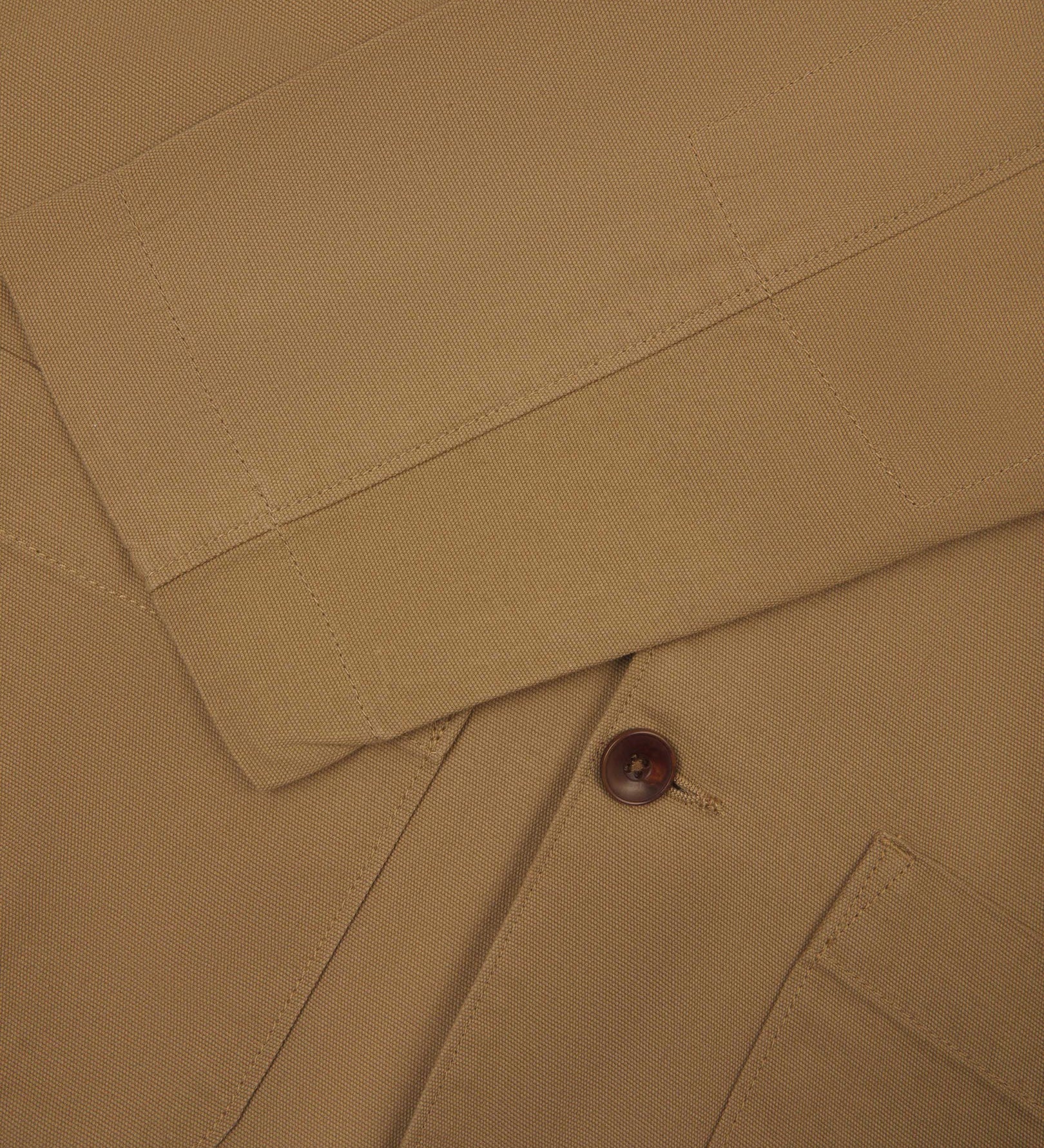 Close-up view of cuff and placket of organic cotton, khaki green blazer from Uskees.