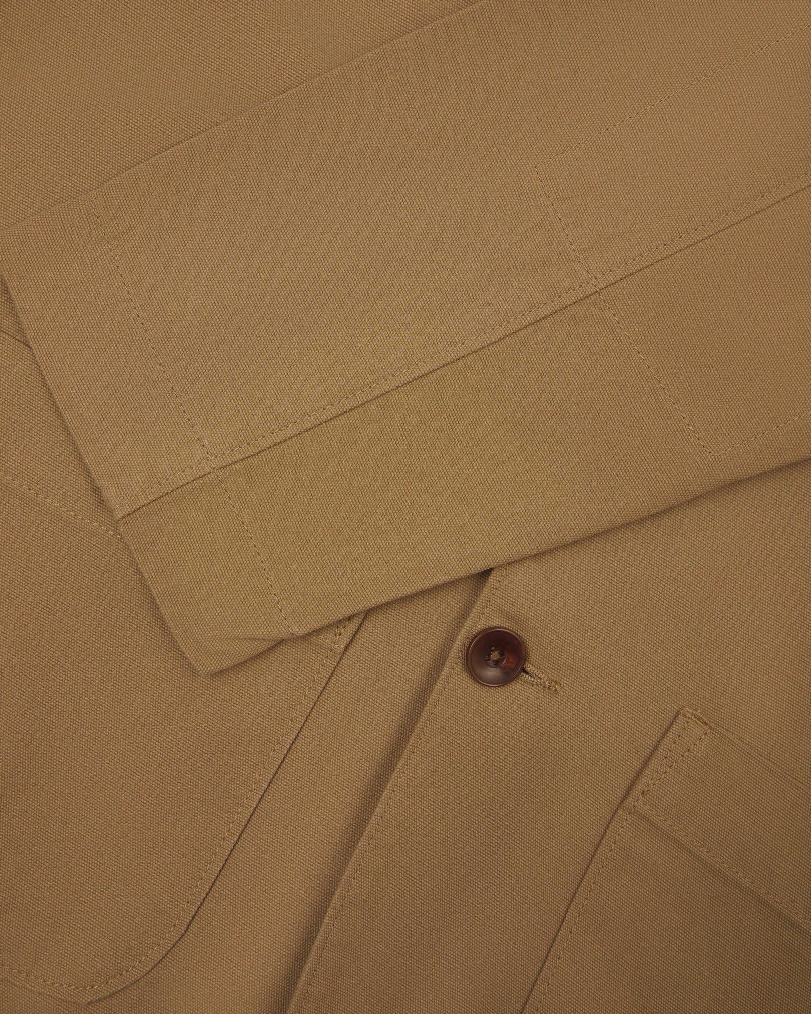 Close-up view of cuff and placket of organic cotton, khaki green blazer from Uskees.