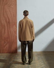 Full-length back view of model wearing 3006, khaki blazer paired with vine green Uskees pants and shirt.