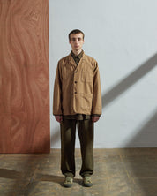 Full-length front view of model wearing 3006, khaki blazer paired with vine green Uskees pants and shirt.