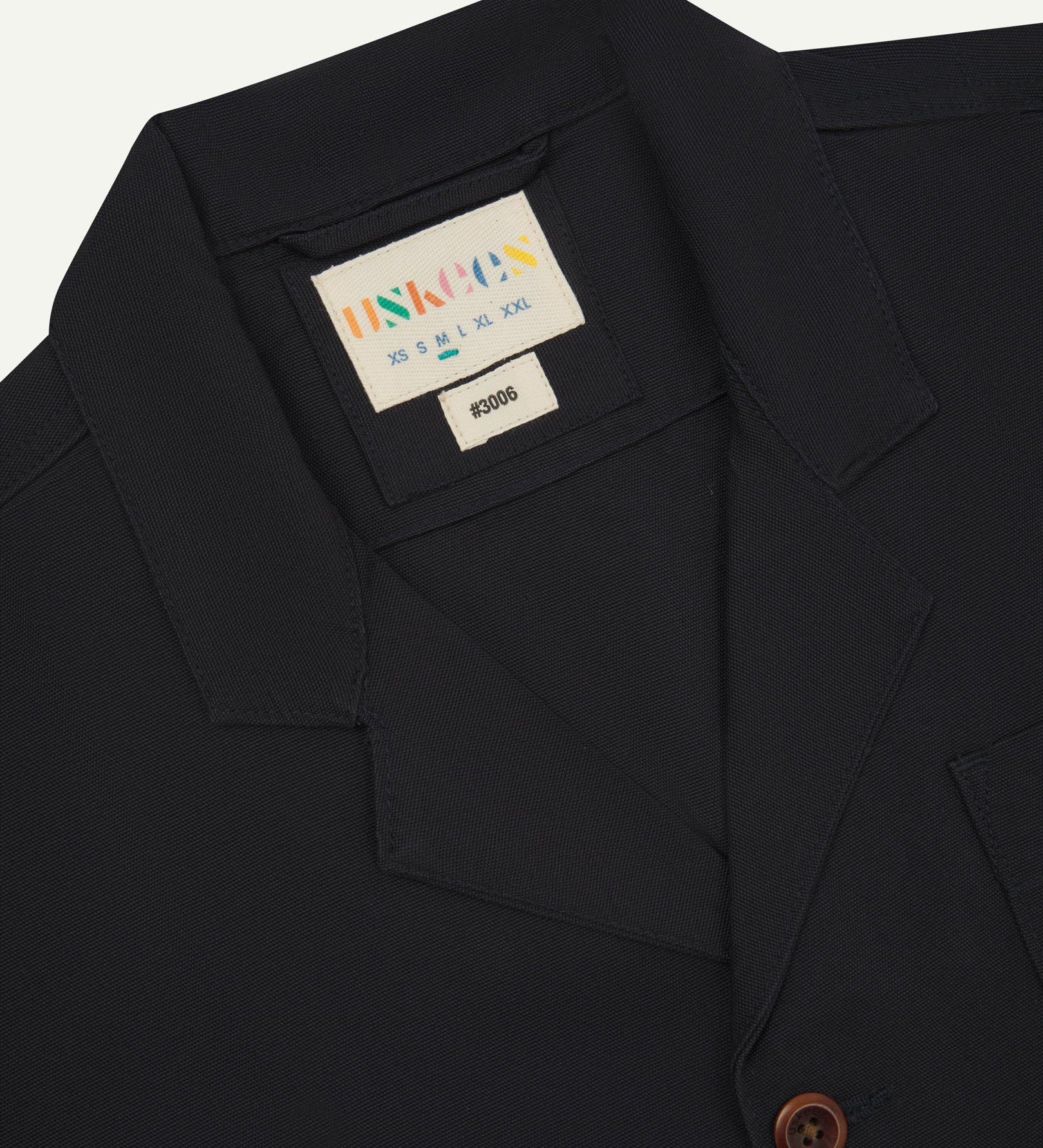 Close-up front view of organic cotton midnight blue blazer showing the collar, lapels and Uskees brand label.