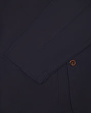 Close-up view of cuff, pocket and button of organic cotton, midnight blue blazer from Uskees.