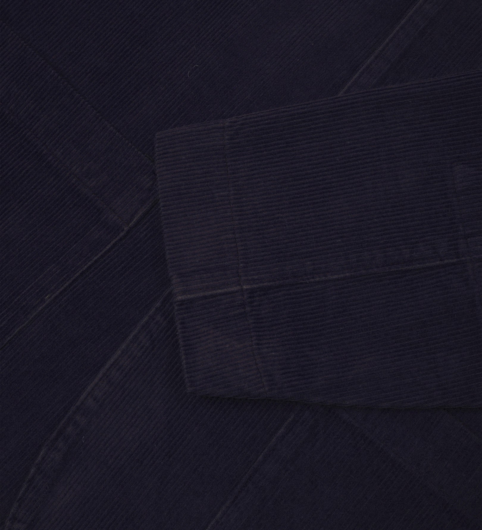 Close-up view of cuff and placket of organic corduroy, midnight blue blazer from Uskees.