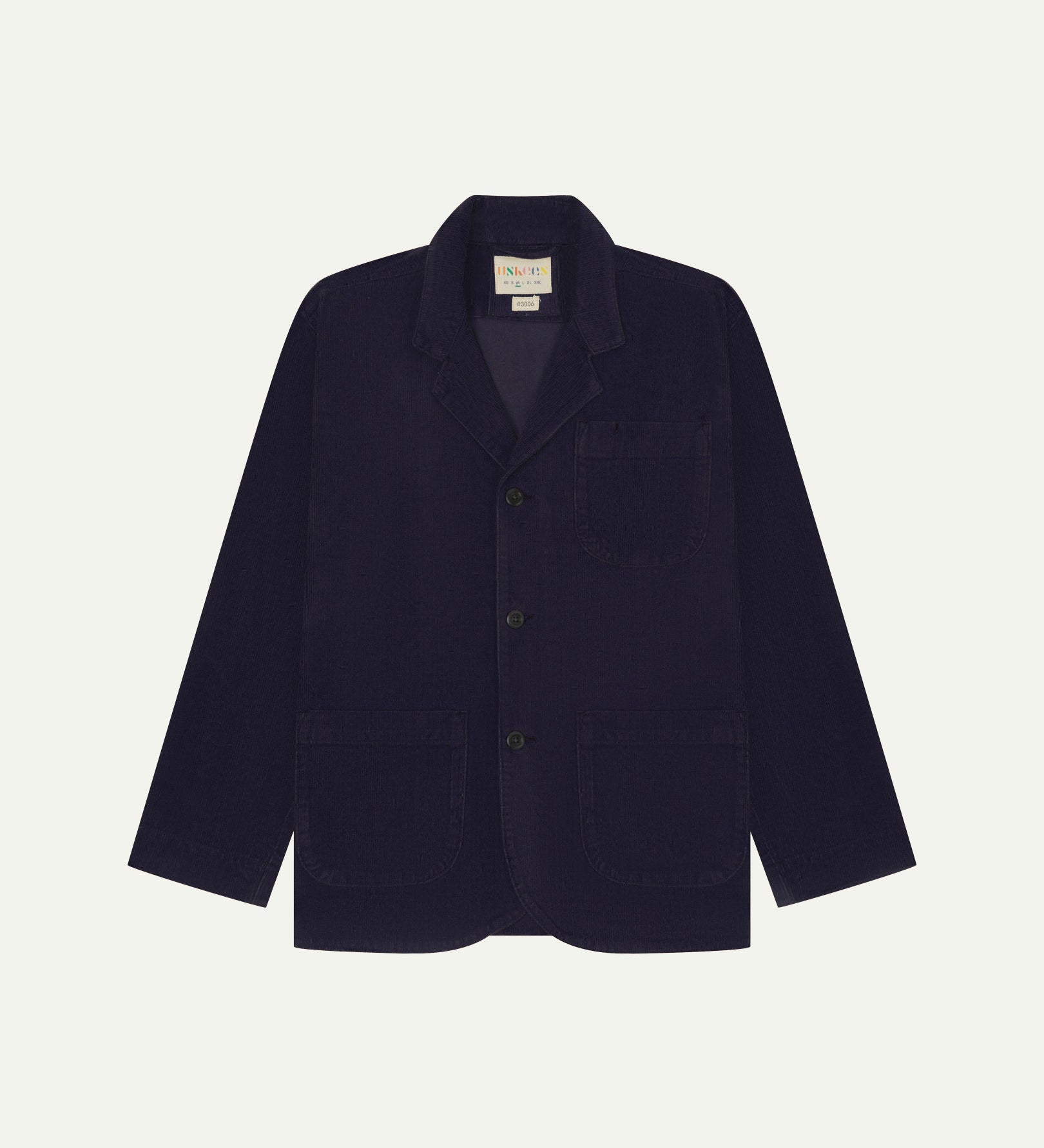 Flat front view of corduroy midnight blue blazer with 3 patch pockets from Uskees. Clearly showing corozo buttons and 3 pockets on the front.