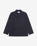 Full front view of deep blue buttoned organic cotton-twill blazer with clear view of three patch pockets and Uskees branding label.
