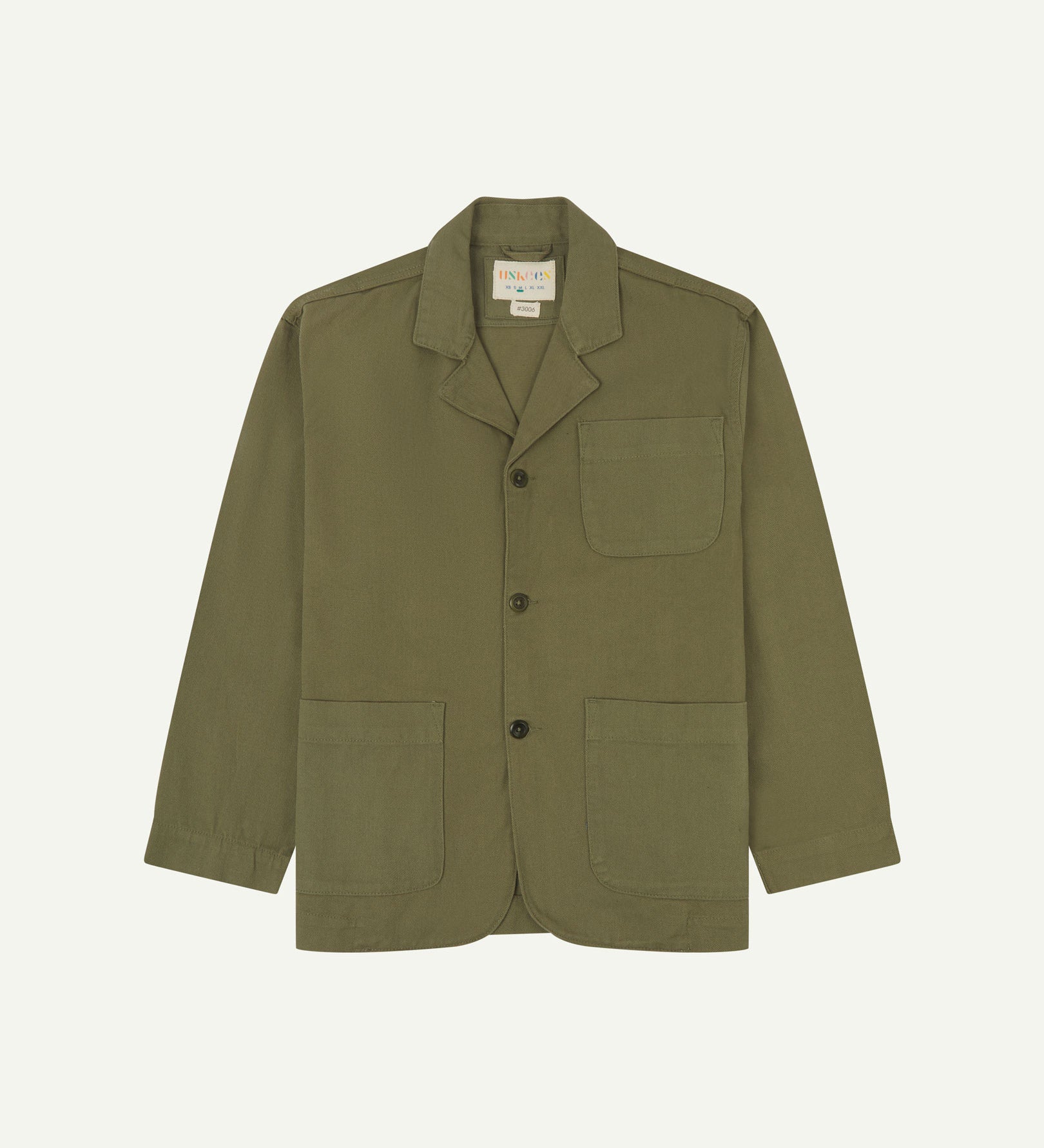 Moss-green buttoned organic cotton-drill blazer from Uskees with clear view of three patch pockets and Uskees branding label.