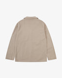 Reverse of oatmeal (beige) buttoned organic cotton-drill blazer from Uskees showing reinforced elbows and boxy silhouette.