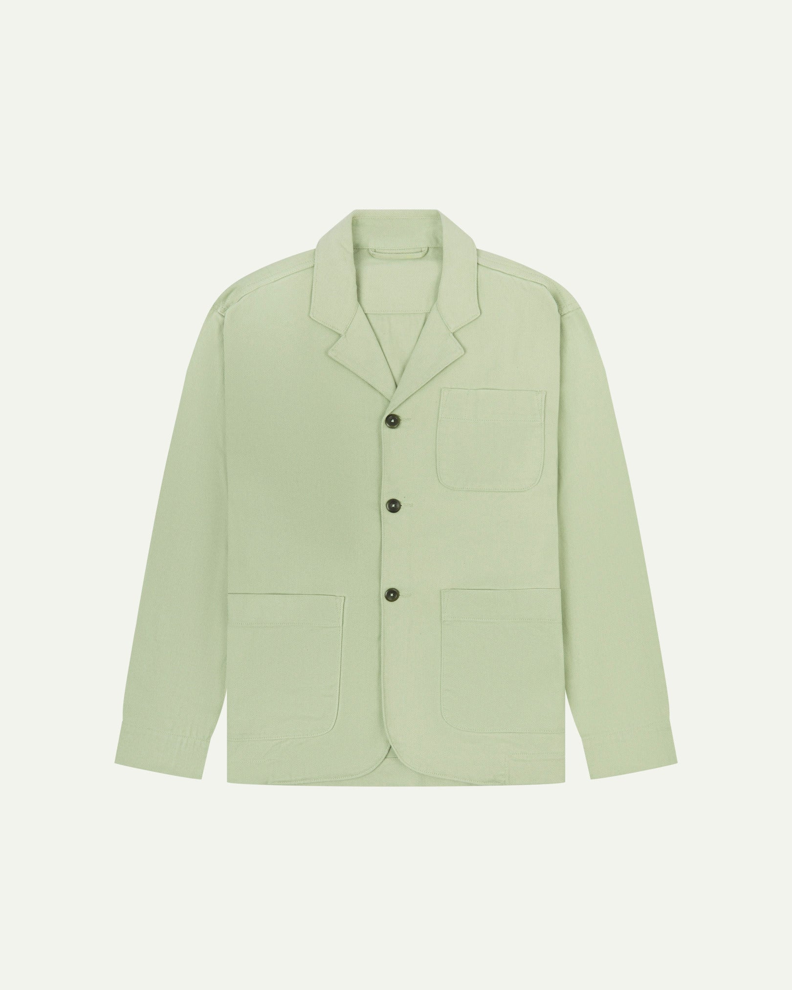 Silver-green buttoned organic cotton-drill blazer from Uskees with clear view of three patch pockets and corozo buttons.