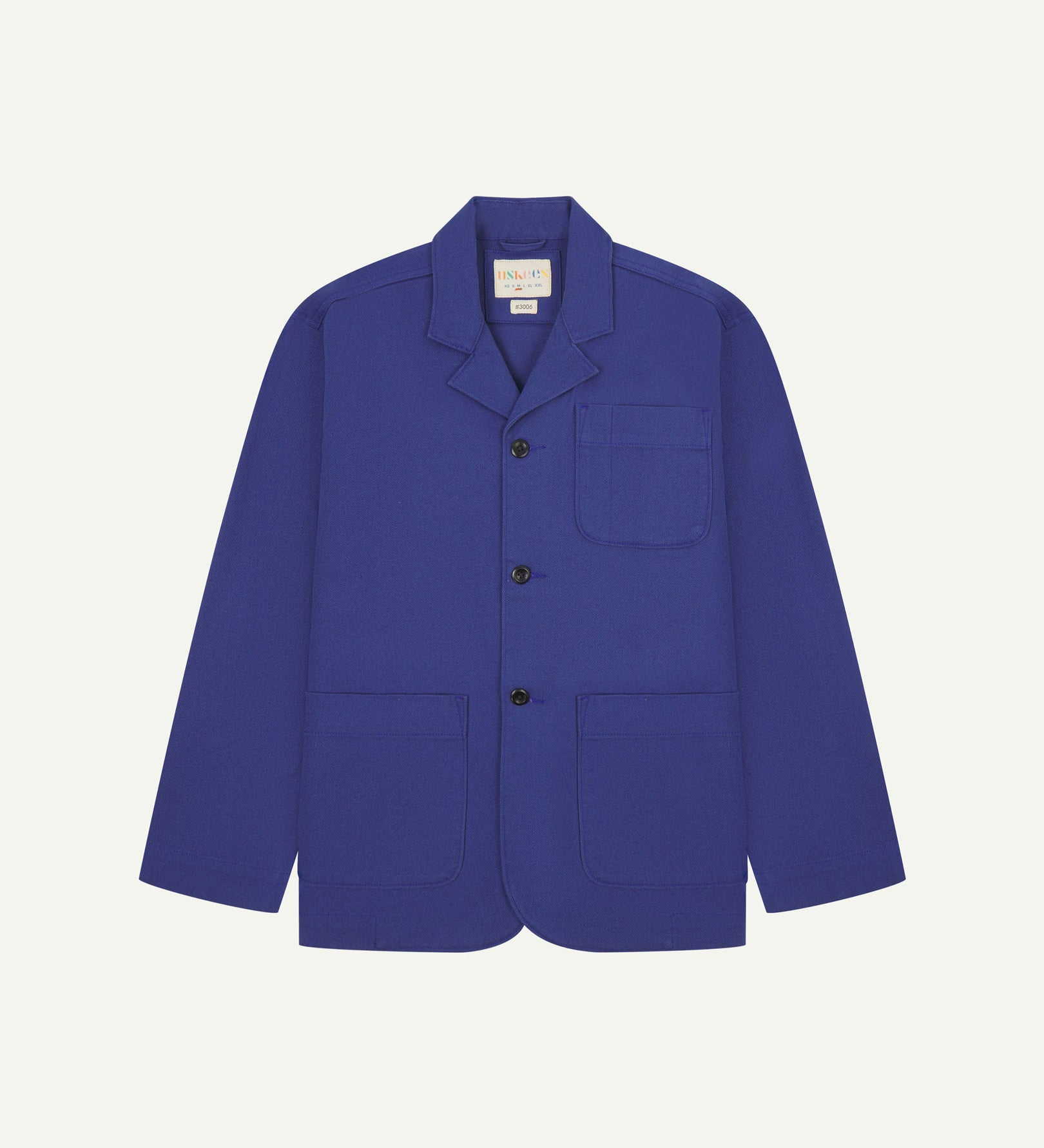Ultra blue buttoned organic cotton-drill blazer from Uskees with clear view of three patch pockets and Uskees branding label.