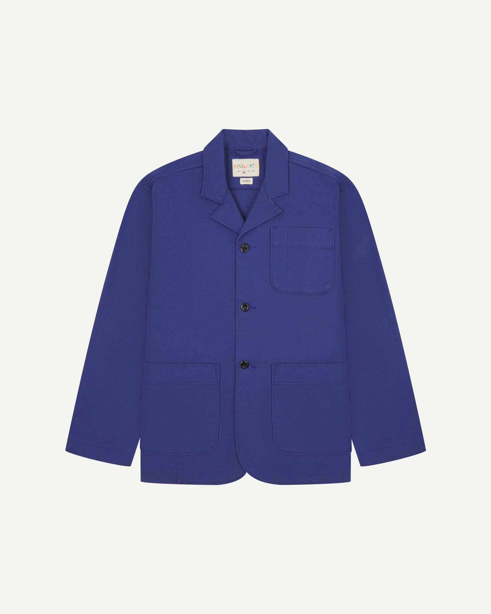 Ultra blue buttoned organic cotton-drill blazer from Uskees with clear view of three patch pockets and Uskees branding label.