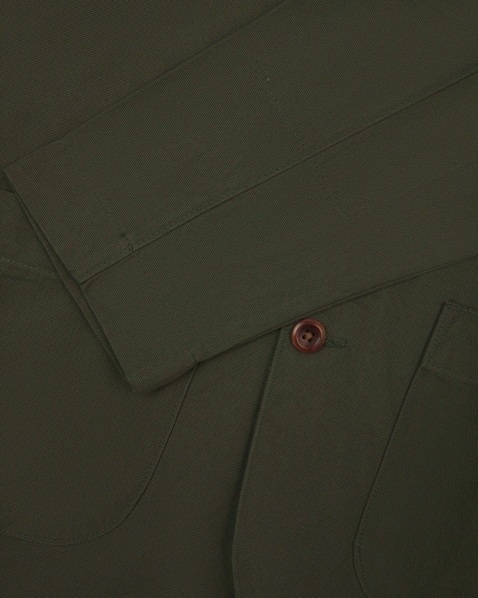 Close-up view of cuff and placket of organic cotton, vine green blazer from Uskees.