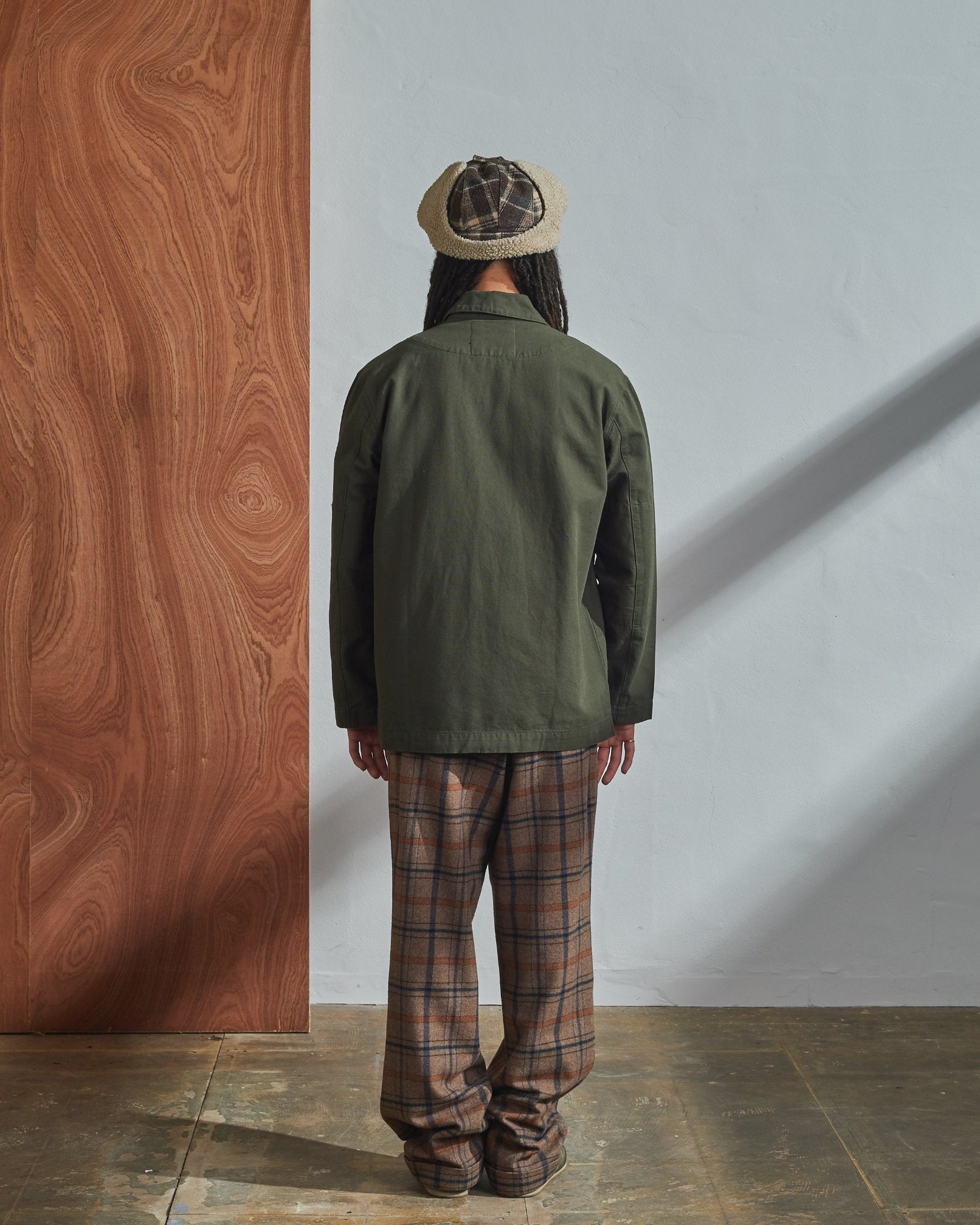 Full-length back view of model wearing 3006, vine green blazer paired with loose checkered pants and white T-shirt.