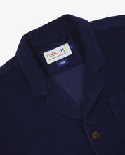 Deep blue jacket with an Uskees brand label  showing at the neck presented on a white background
