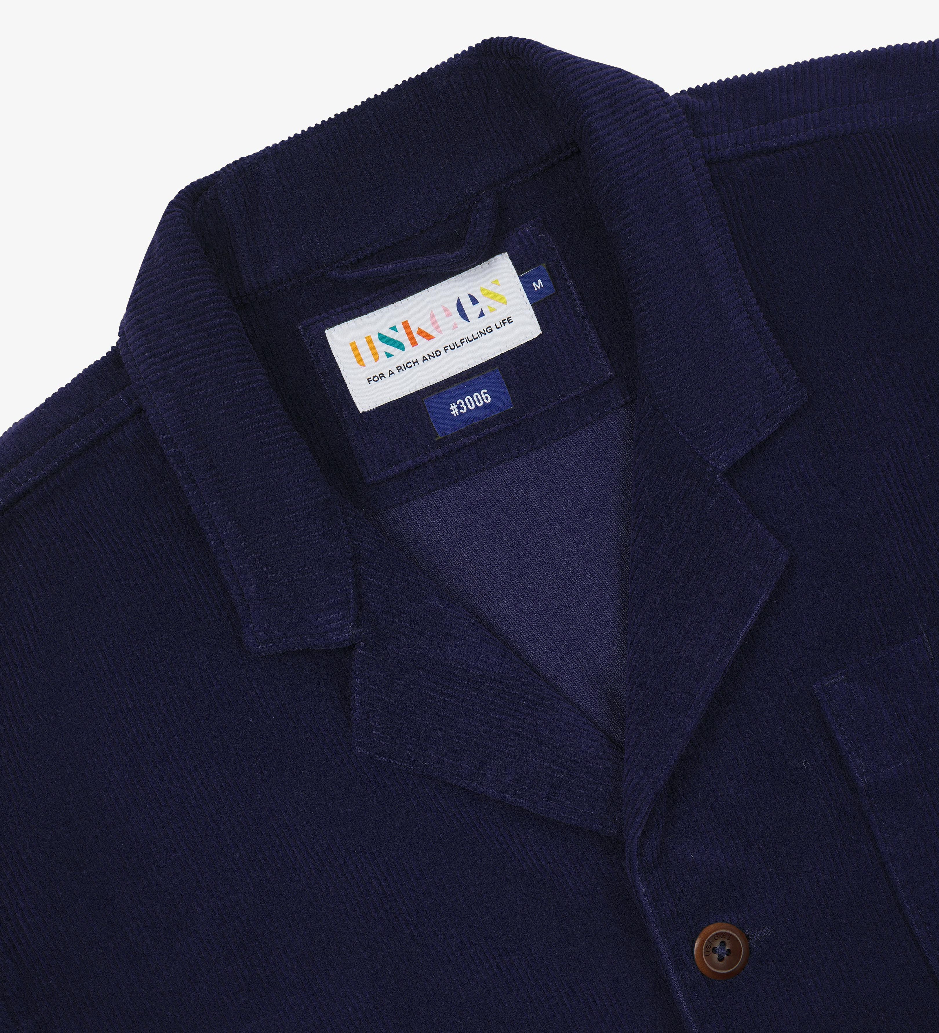 Deep blue jacket with an Uskees brand label  showing at the neck presented on a white background