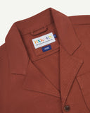 Chestnut Brown Uskees jacket showing the brand label at neck, presented on a white background