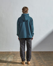 Full-length rear view of #3008 smock in peacock-blue showing reinforced elbows and simple loose boxy design.