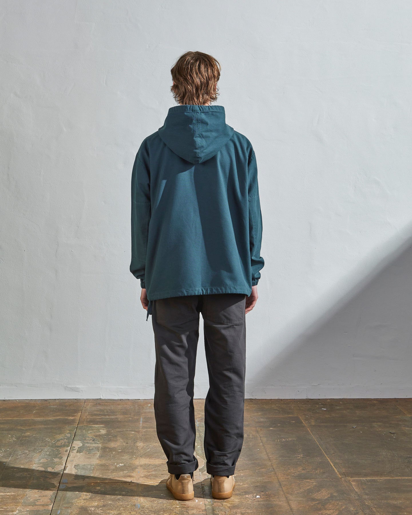 Full-length rear view of #3008 smock in peacock-blue showing reinforced elbows and simple loose boxy design.