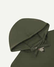 Closer look at the hood of the Uskees organic cotton smock in vine green showing hood, hood drawstring and quadruply stitched neck area.
